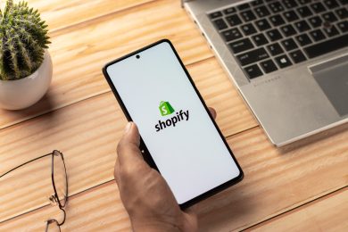 Smartphone running Shopify next to a laptop