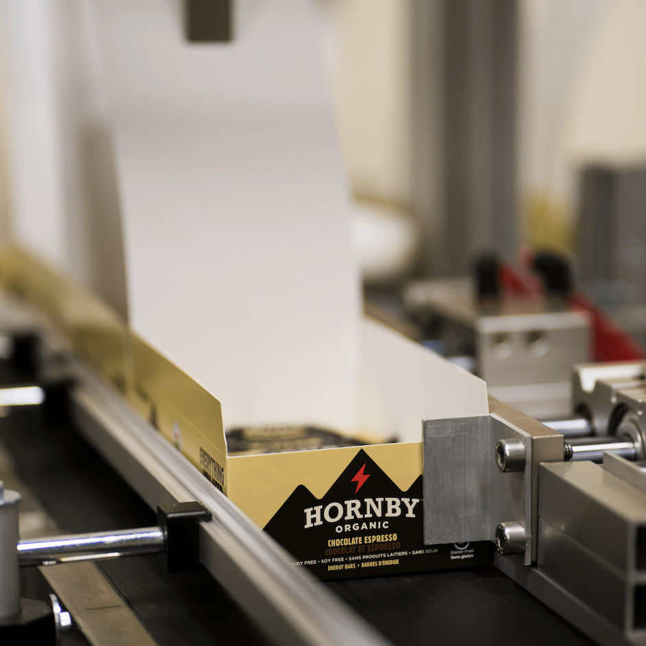 Hornby Organic bars in a box on a conveyor belt