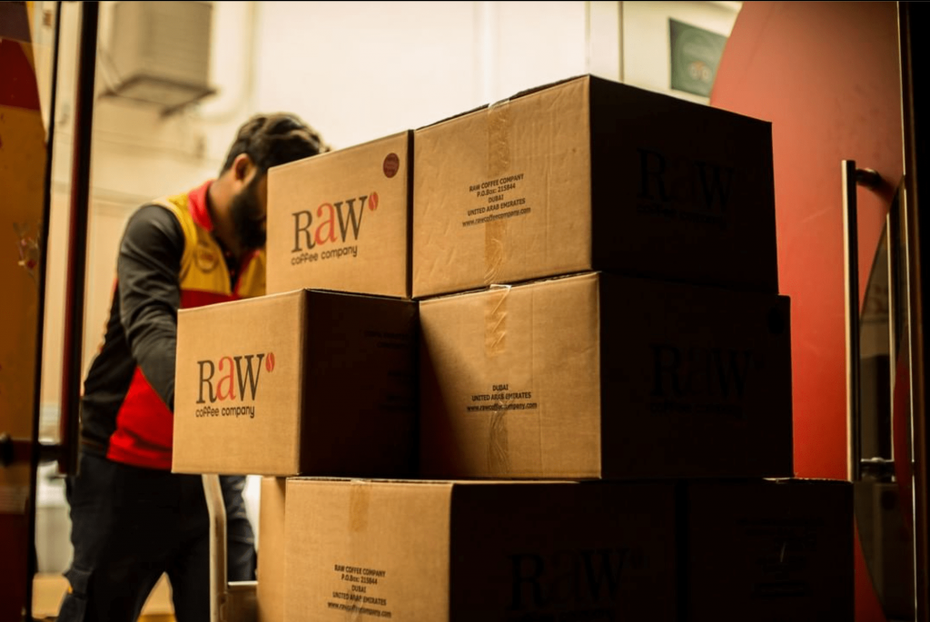 Pile of boxes in inventory with raw coffee company logo 