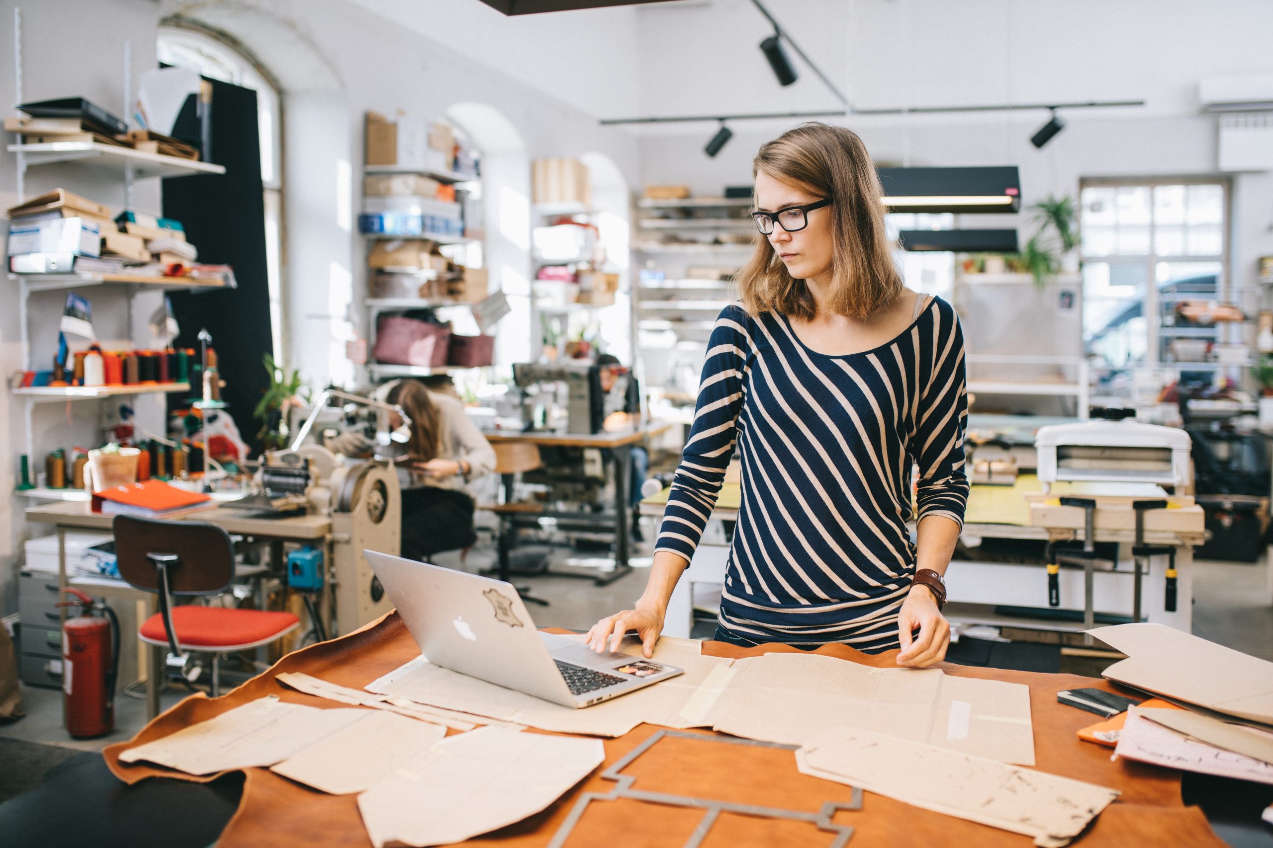 Leather manufacturer learning how to calculate selling price on her shop floor.