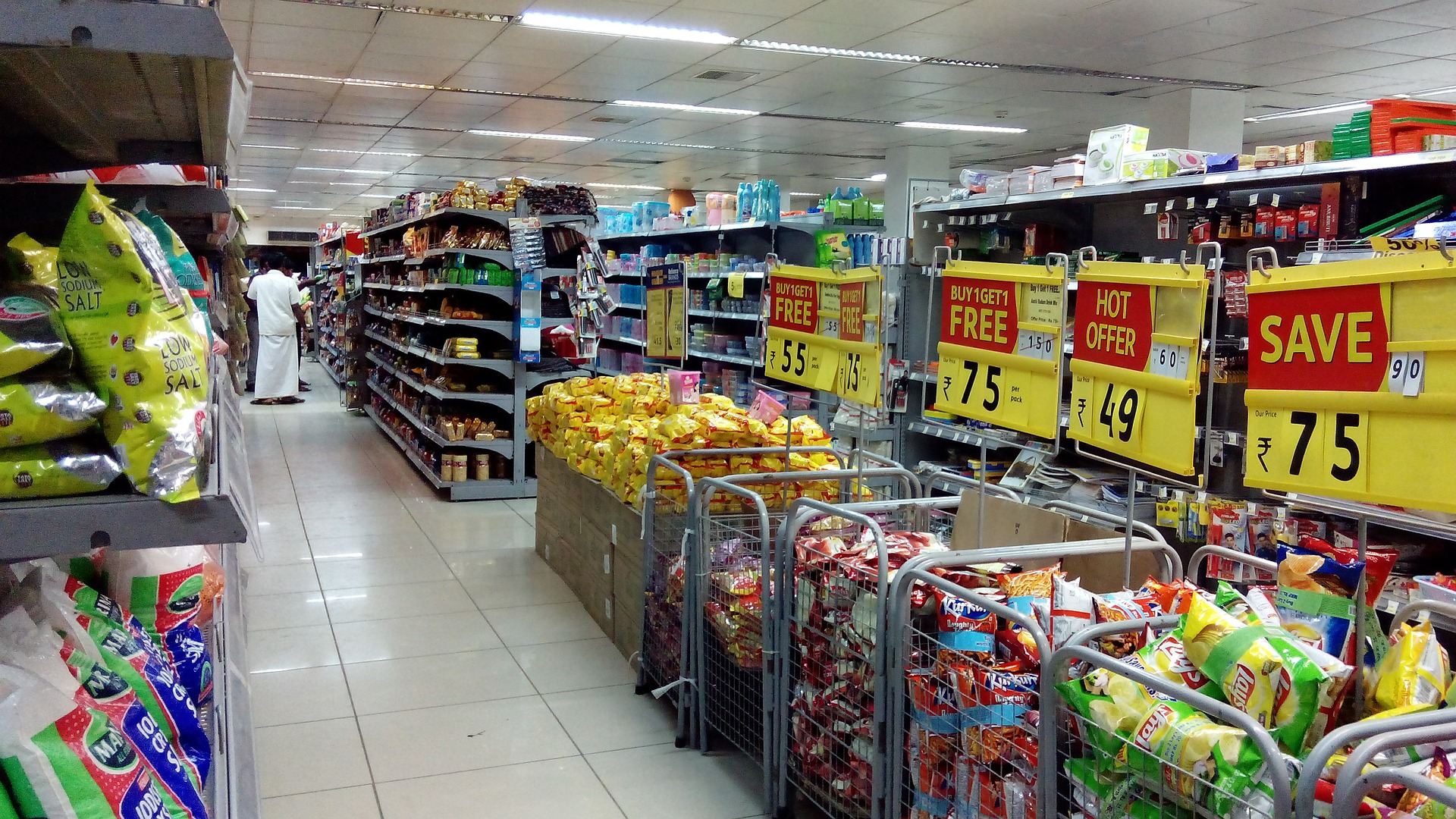 Grocery store with shelves filled with products and their selling price is clearly highlighted. 