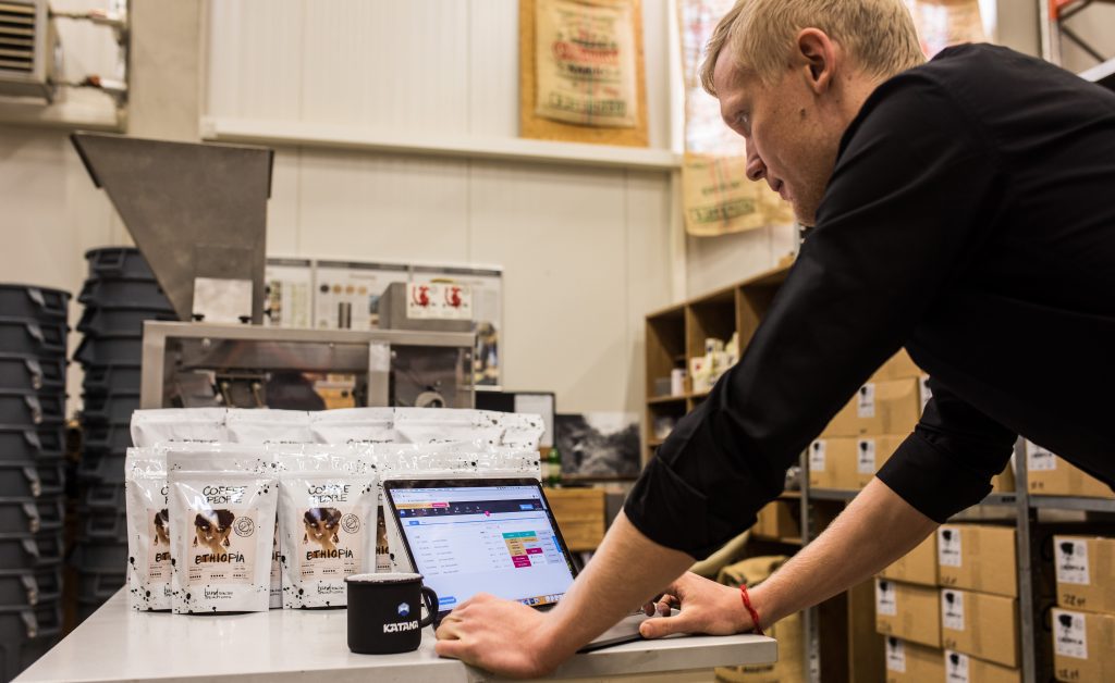 Coffee maker using eco-friendly manufacturing software to track inventory and update the status of orders. 