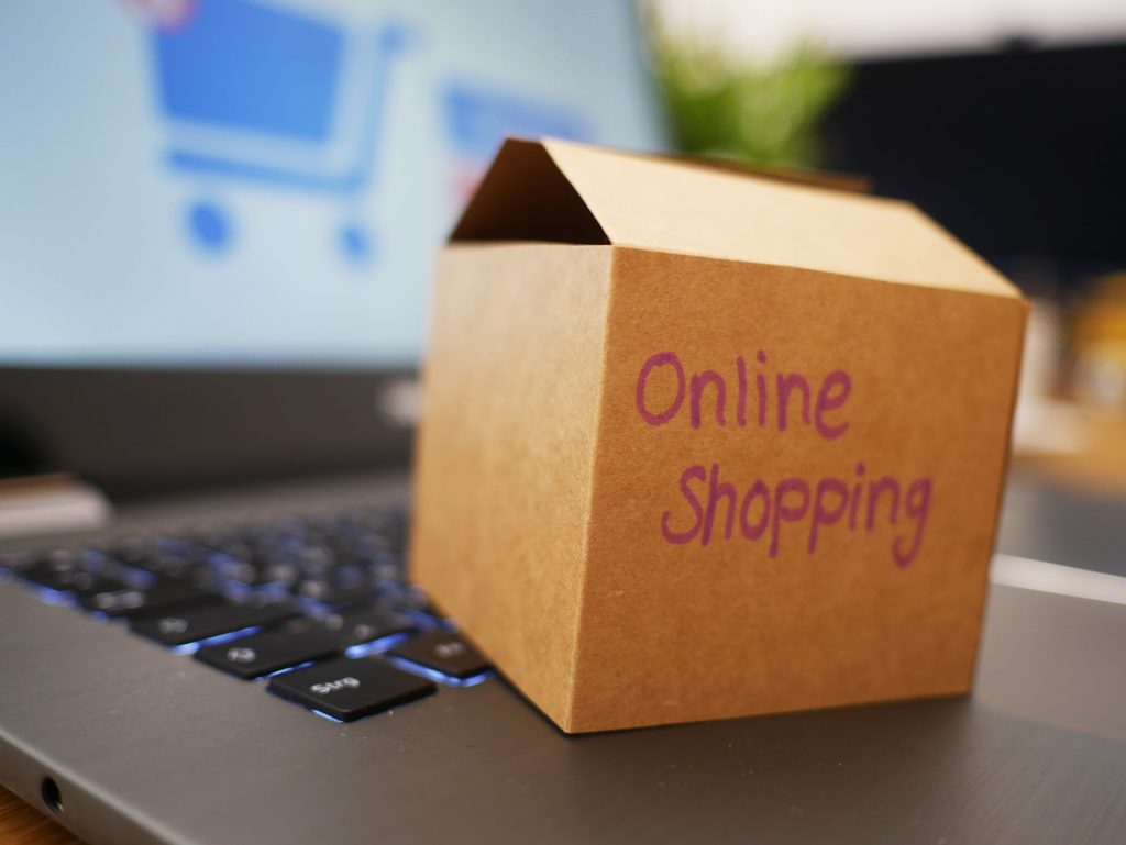 Miniature cardboard box on a laptop as a reference to e-commerce for Shopify Plus vs Shopify. 