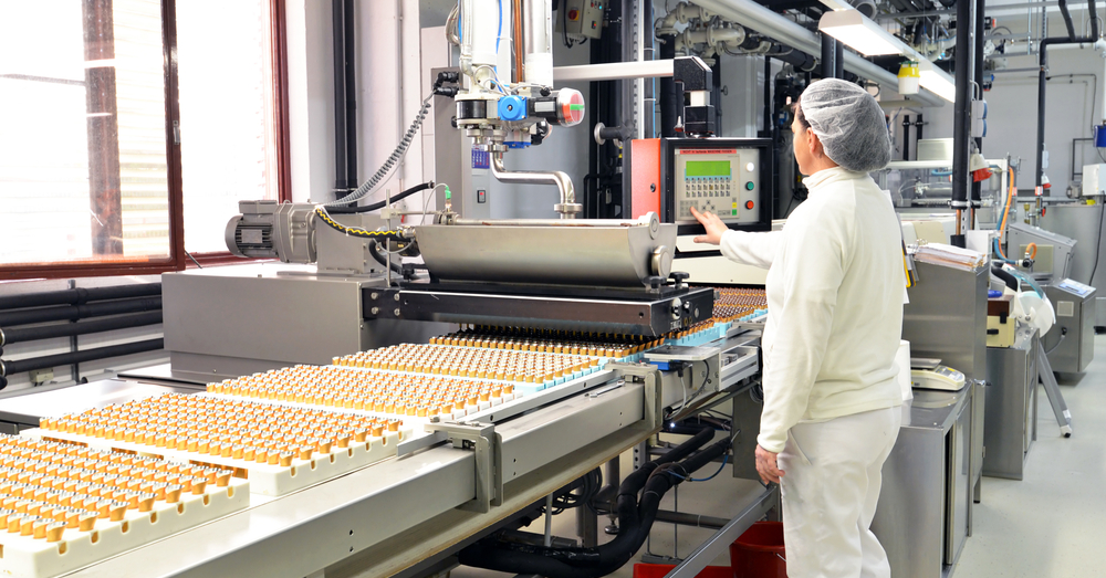 Employees working on a production line in a factory that uses a repetitive manufacturing system.