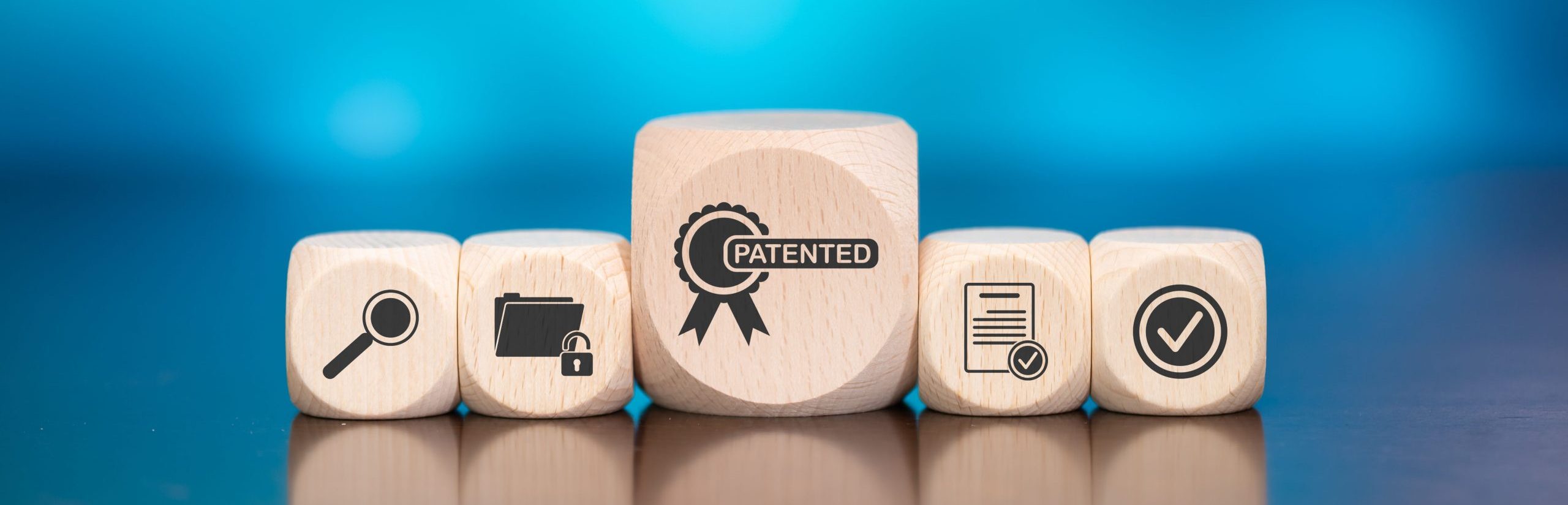 Wooden Blocks With Symbols representing intellectual property on Blue Background