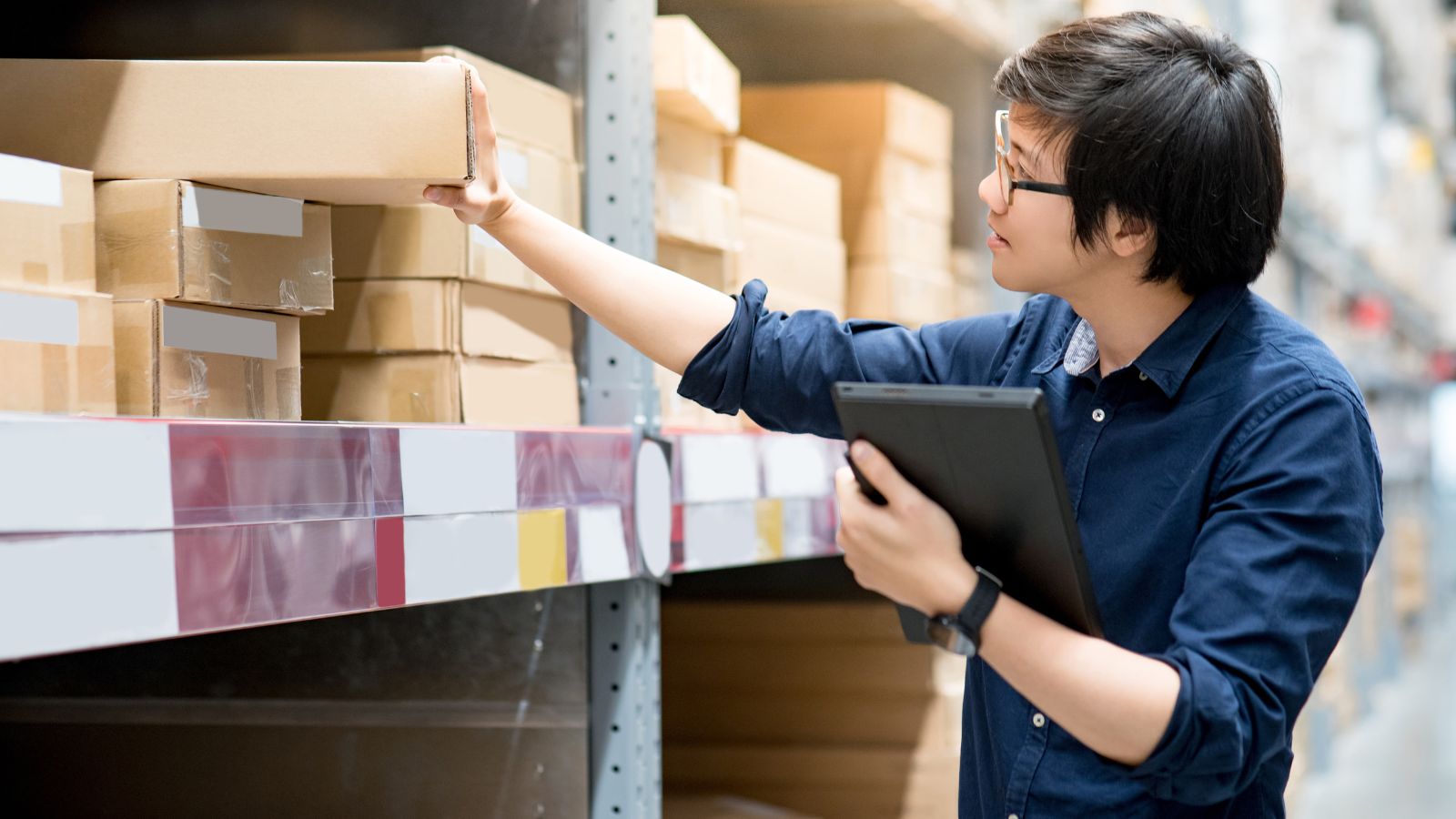 A man looking through his finished goods inventory in a warehouse