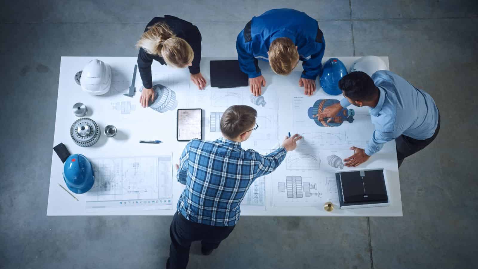 Workers around a desk looking at plans