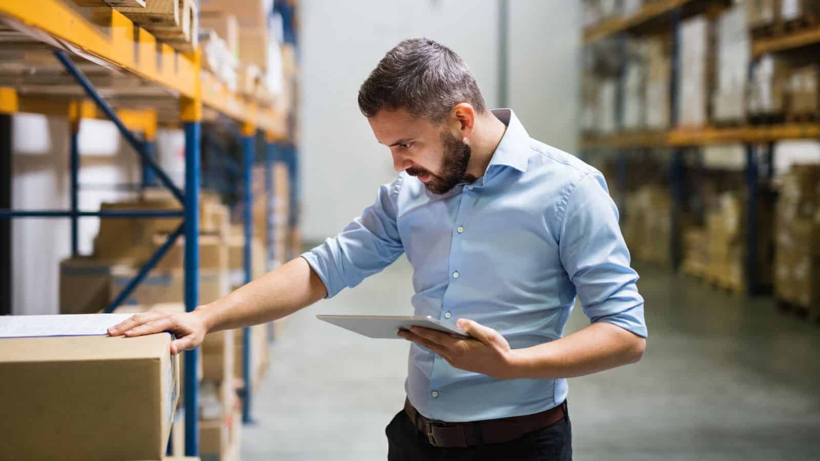 A male worker in a warehouse looking into items for decoupling inventory.