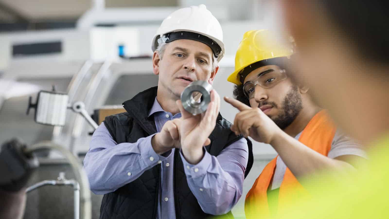 Two workers performing quality control in manufacturing inspections