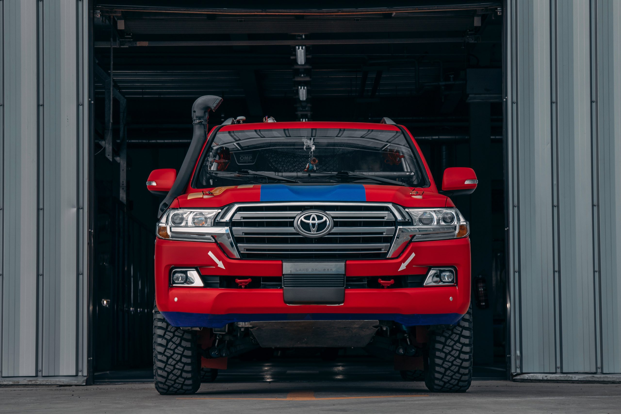 Toyota Land Cruiser driving out of a factory