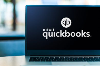 QuickBooks logo with a dark background displayed on a laptop screen