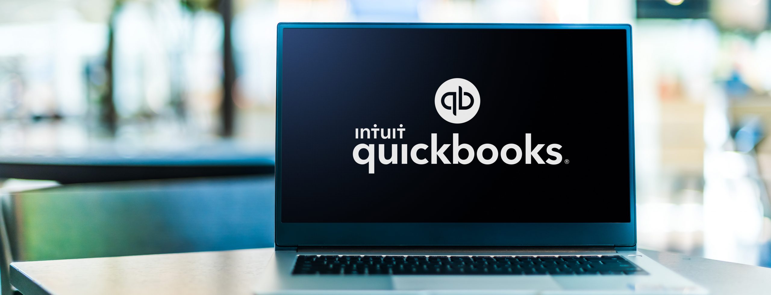 QuickBooks logo with a dark background displayed on a laptop screen