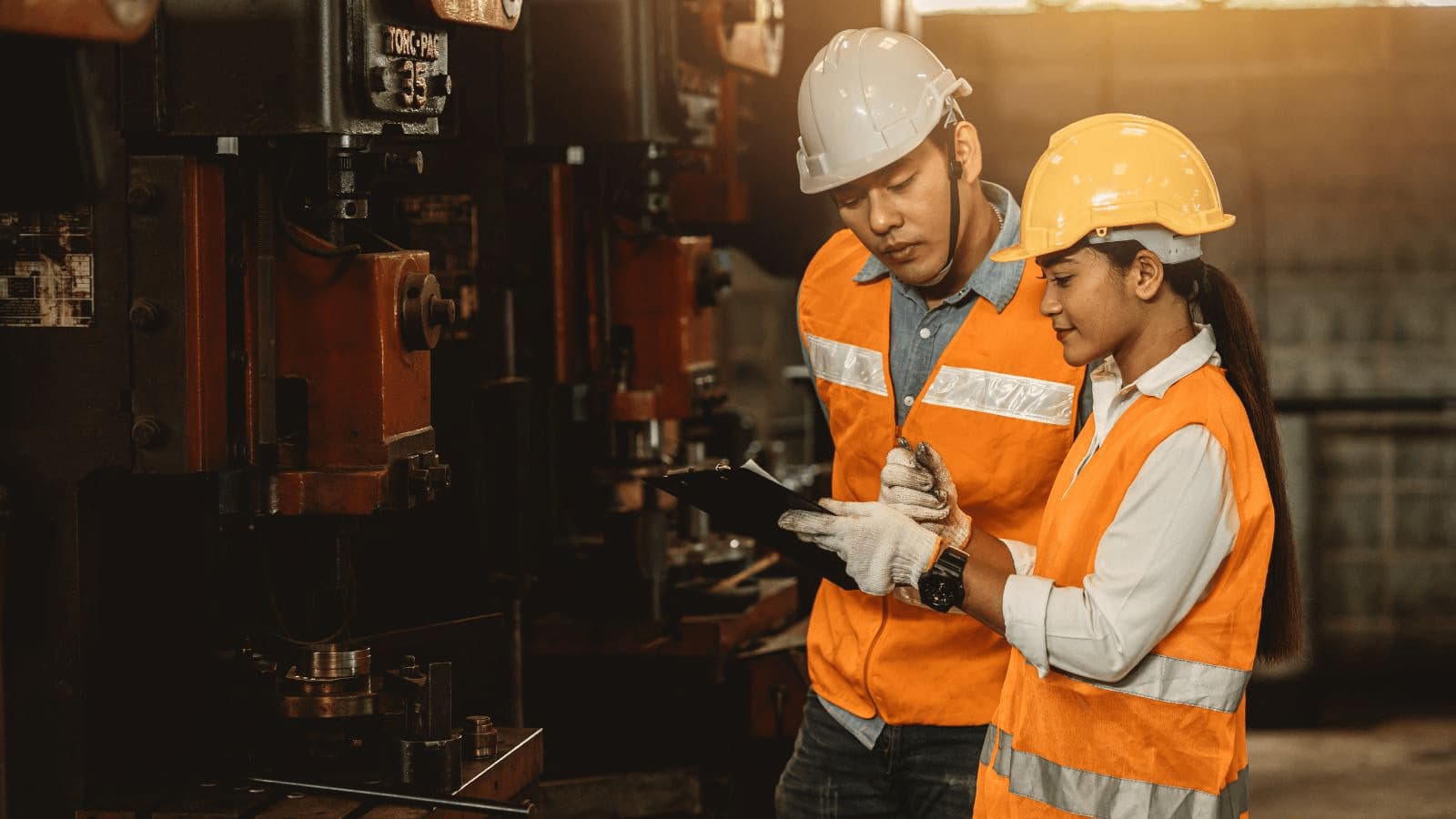 Man and woman in PPE equipment check their plan and schedule on their APS software.