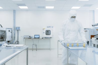 A man carrying a batch of the finished product in a laboratory.