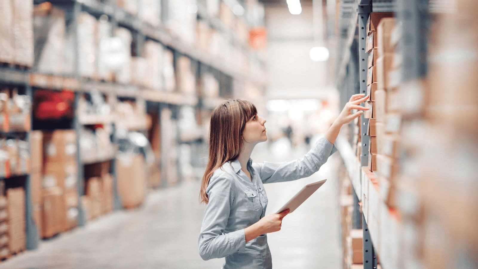 A woman performs a stocktake using a smart device to adjust inventory in QuickBooks Online.