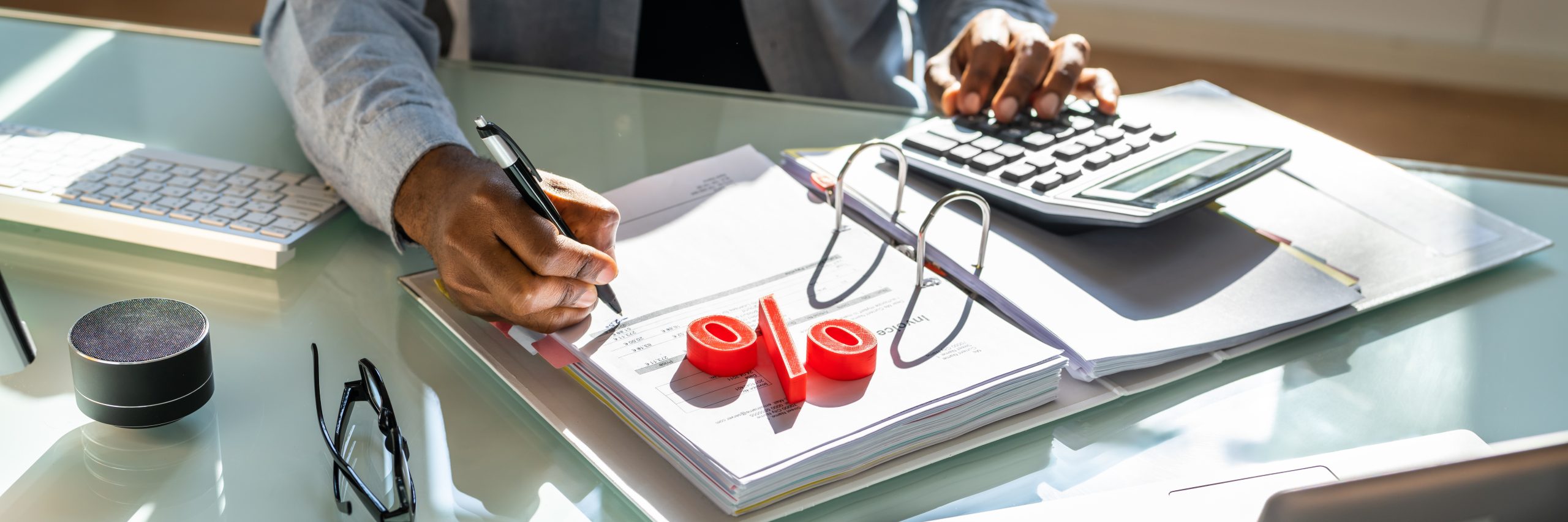 Worker using a calculator and writing on an invoice