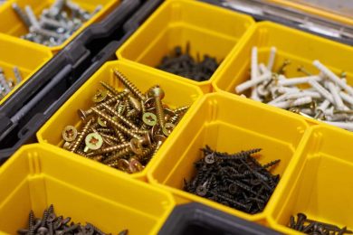 A collection of screws in yellow trays which are a part of a business's non-inventory.