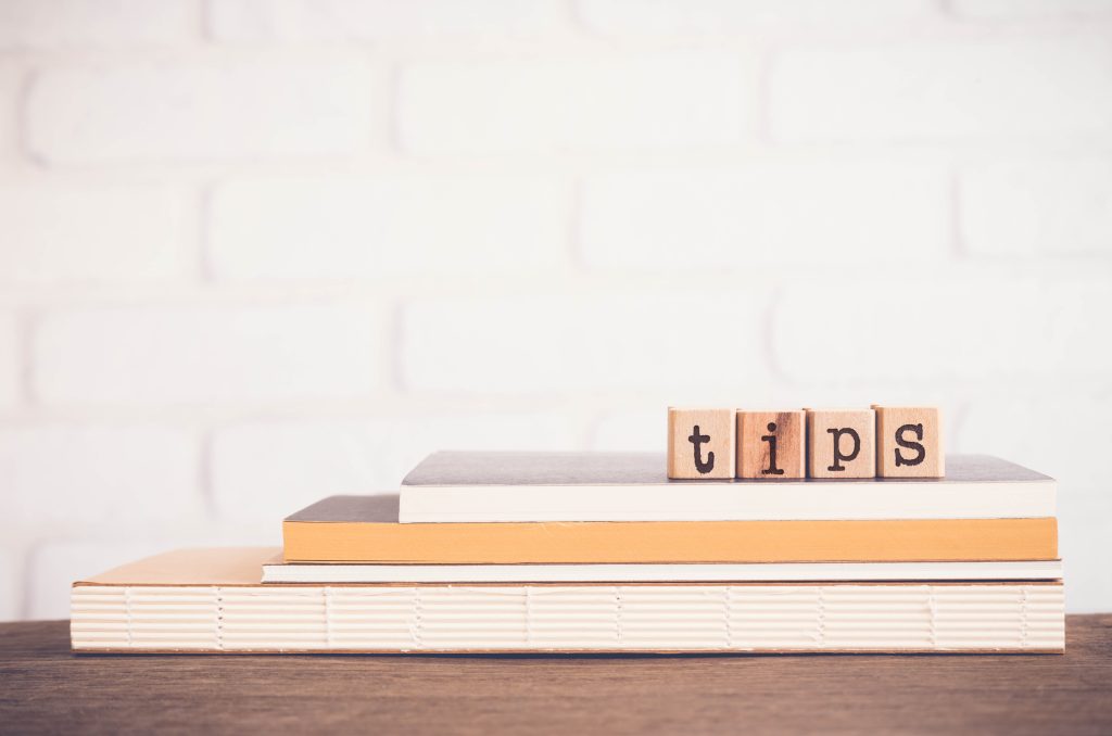 Wooden blocks spelling out "tips" on top of notebooks