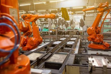 Robot arms on assembly lines in digital manufacturing.