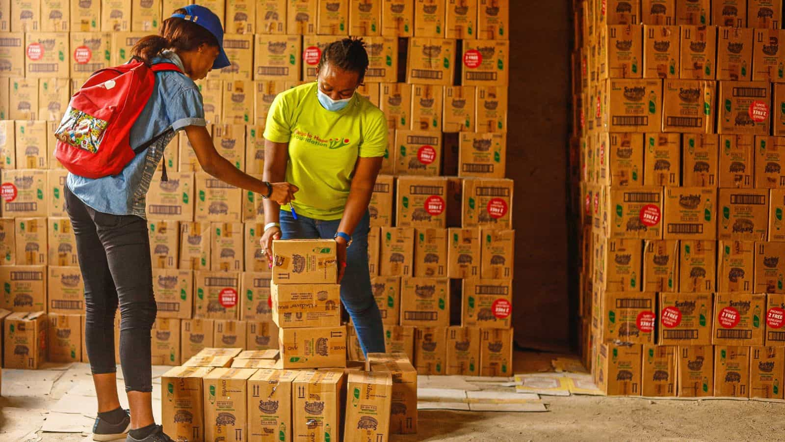 Two workers stacking inventory in a warehouse. 