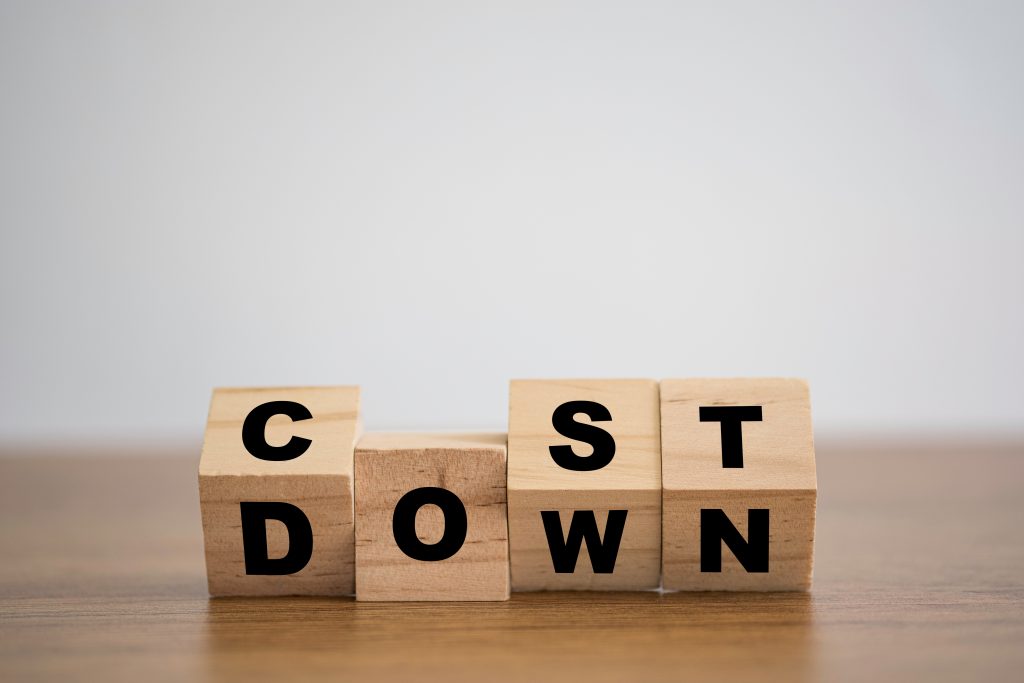 Wooden blocks spelling out "cost down"