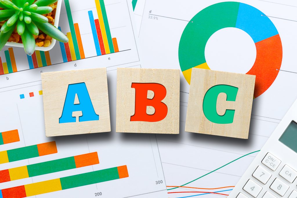 Wooden blocks on top of documents on a desk spelling out ABC