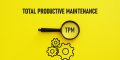 Total productive maintenance printed on a yellow background with gear icons and a magnifying glass