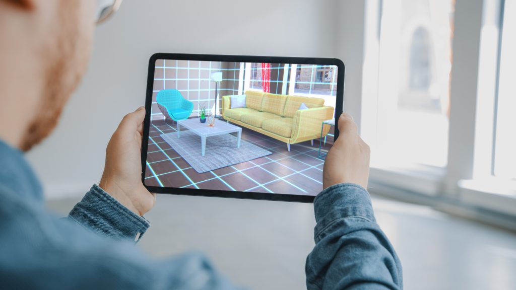 Person holding a tablet and using an AR app to pick furniture