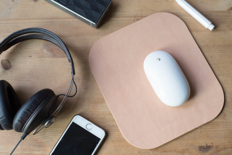 Top view of a mouse, headphones, mobile phone on a desk