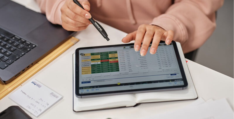 person looking through a list of purchase orders on a tablet computer